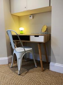 a desk with a chair and a lamp on it at Cosy Central Hideaway in St. Leonards
