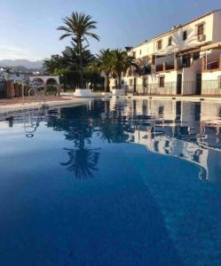 a large pool with blue water in front of a building at Almijarahouse in Nerja