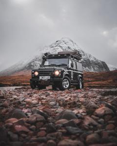 un jeep estacionado frente a una montaña cubierta de nieve en Land Rover Defender Luxury Camper, en Morpeth