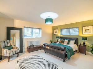 a large bedroom with a bed and a chair at The Golf House in Bidston