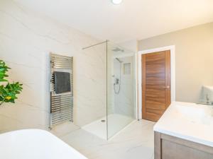 a bathroom with a shower with a glass door at The Golf House in Bidston