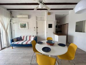 a living room with a white table and yellow chairs at 4DEMO2 Appartement vue mer in Collioure