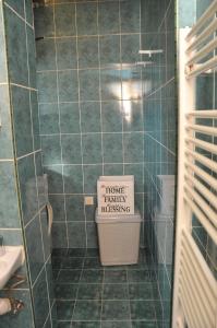 a bathroom with a trash can with a sign on it at Apartment with parking in the free garage in Sarajevo