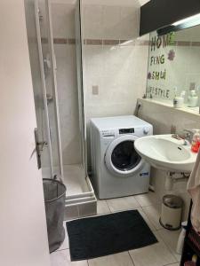 a bathroom with a washing machine and a sink at Logement plein centre royan in Royan
