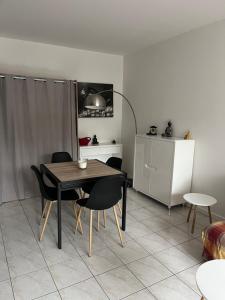 a dining room table and chairs in a kitchen at Logement plein centre royan in Royan