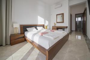 sypialnia z dużym łóżkiem z białą pościelą w obiekcie Olymp Luxury Villa D w Pafos