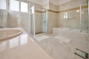 a bathroom with a tub and a sink and a shower at Olymp Luxury Villa D in Paphos City