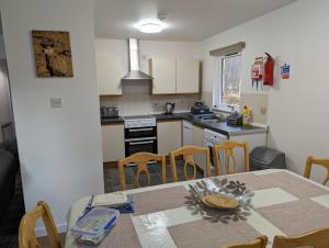 a kitchen with a table and chairs in a room at The Little Houses in Roybridge