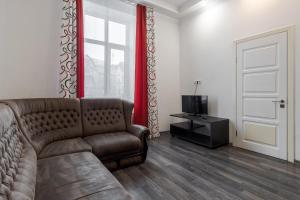 a living room with a brown couch and a television at Halytska apartment in Lviv