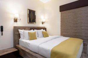 ein Schlafzimmer mit einem großen Bett mit weißen und gelben Kissen in der Unterkunft BKT Cribs - Apartments & Suites in Abuja