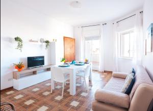 a living room with a white table and a couch at da subito libera Dune Dorate,Tramonti Infiniti la tua oasi di pace in Dune ! Aprile al Mare in Appartamento con vista panoramica e WiFi Casa Vacanza Vista Mare in Sicilia Relax e Tramonti Unici in Alcamo Marina