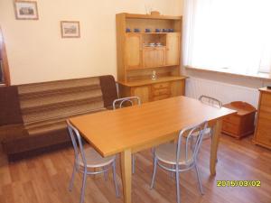 a dining room with a wooden table and chairs at Apartament - Stronie Śląskie in Stronie Śląskie