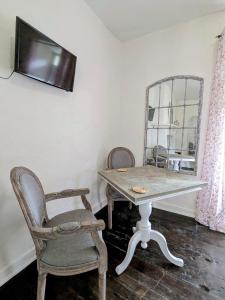 a table and a chair and a mirror in a room at Sous le Chateau in Jumilhac-le-Grand