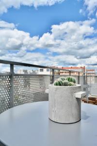 una mesa en un balcón con una maceta en 5-Min Paris, Lovely Eco Brand-New Sun-Bathed Apt !, en Aubervilliers