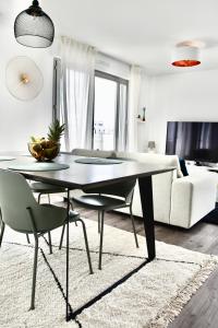 uma sala de estar com uma mesa e um sofá em 5-Min Paris, Lovely Eco Brand-New Sun-Bathed Apt ! em Aubervilliers