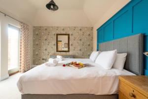 a large white bed with a tray of fruit on it at Alde Bay Farm - Coral Cottage in Aldeburgh