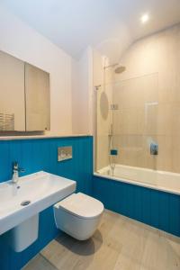 a bathroom with a toilet and a sink and a shower at Alde Bay Farm - Coral Cottage in Aldeburgh