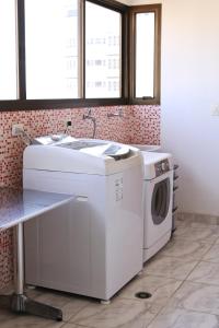 lavadero con lavadora y fregadero en Apt no Alto de Pinheiros, en São Paulo