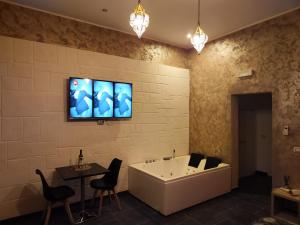 a bathroom with a tub and a tv on the wall at Suite Marrakech in Taranto