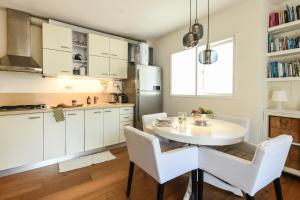 a kitchen with white cabinets and a white table and chairs at Radiant 1BR Apt w Parking in the Heart of Tel Aviv by Sea N' Rent in Tel Aviv