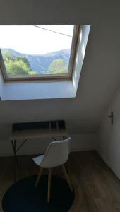 einen weißen Stuhl in einem Zimmer mit Fenster in der Unterkunft le beau coin, unique et magique 