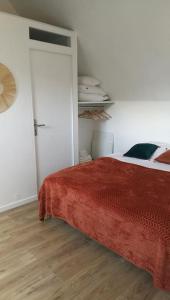 ein Schlafzimmer mit einem Bett mit einer roten Decke darauf in der Unterkunft le beau coin, unique et magique 