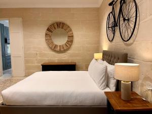 a bedroom with a bed with a bicycle on the wall at Typical Maltese Maisonette in St.Julians in St. Julianʼs