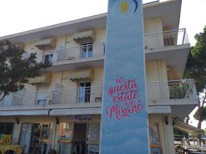 a sign on a pole in front of a building at Hotel Franca in Misano Adriatico