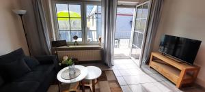 een woonkamer met een bank, een tv en een tafel bij Apartment In Spay Smile Zell-Merl Mosel in Zell an der Mosel