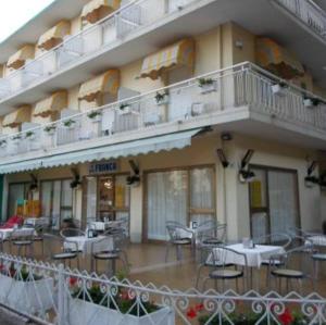 a hotel with tables and chairs in front of a building at Hotel Franca in Misano Adriatico