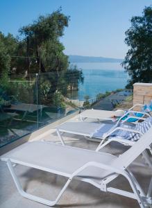 un paio di letti su un balcone con vista sull'oceano di Villa Nikolakis Kerasia, on the beach a (( Kerasá ))