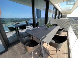 une table et des chaises sur le balcon d'un bâtiment dans l'établissement BW TERRACE top floor apartments with river view & self check-in, à Belgrade