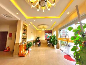 un vestíbulo de un edificio con una lámpara de araña y plantas en Dalat Holiday Hotel, en Da Lat