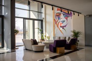 a lobby with chairs and a painting on the wall at Calisi Hotel in Belgrade