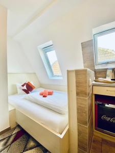 M-Hotel في شتوتغارت: غرفة نوم صغيرة مع سرير مع نافذتين