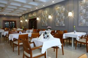 Hotel Termy Pałacowe في ناووتشوف: غرفة طعام مع طاولات وكراسي بيضاء