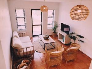 a living room with a couch and chairs and a tv at Struispaleis in Struisbaai