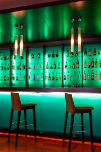 zwei Stühle an einer Bar mit grüner Beleuchtung in der Unterkunft Hotel Macià Real De La Alhambra in Granada