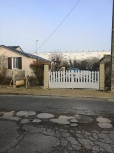 une clôture blanche devant une maison dans l'établissement Belle maison de vacances, à Romilly-sur-Seine