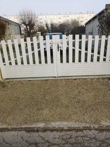 a white picket fence in front of a yard at Belle maison de vacances in Romilly-sur-Seine