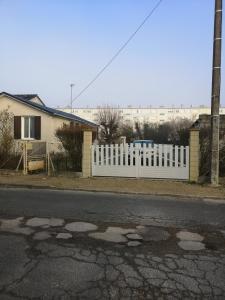 una cerca blanca frente a una casa en Belle maison de vacances en Romilly-sur-Seine