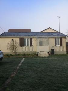 une maison avec une cour d'herbe devant elle dans l'établissement Belle maison de vacances, à Romilly-sur-Seine