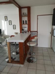 uma cozinha com um balcão e bancos num quarto em Belle maison de vacances em Romilly-sur-Seine