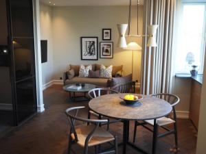 - un salon avec une table, des chaises et un canapé dans l'établissement Hypernym Hotel & Suites, à Copenhague