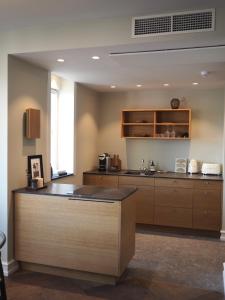 a kitchen with wooden cabinets and a counter top at Hypernym Hotel & Suites in Copenhagen