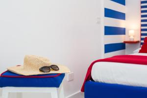 kapelusz i okulary słoneczne siedzące na łóżku w obiekcie Happy flat on the sea w Sorrento