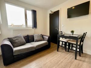 ein Wohnzimmer mit einem Sofa und einem Tisch in der Unterkunft Spacious 1 Bed Apartment In The City Centre in Cardiff