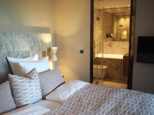 a bedroom with a bed and a bathroom with a shower at Hypernym Hotel & Suites in Copenhagen