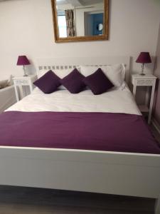 バイユーにあるStudio St Jeanの白い大型ベッド(紫色の枕、鏡付)