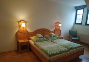 ein Schlafzimmer mit einem Bett mit zwei Kissen darauf in der Unterkunft Hotel Svatý Tomáš in Přední Výtoň